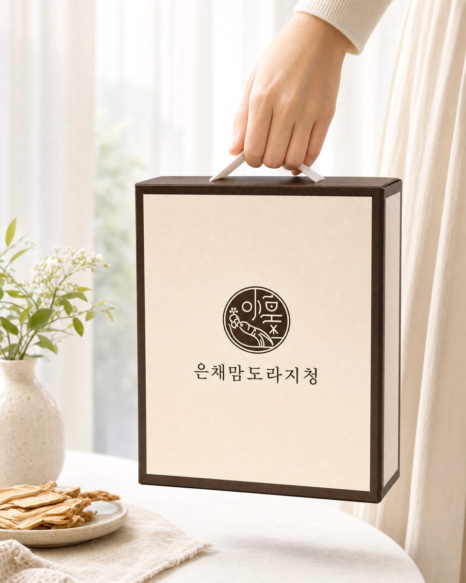 자연광 아래 손에 든 은채맘 도라지청 크림색 선물세트